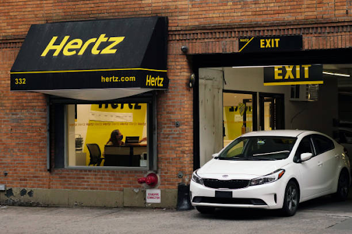 White Kia car at Hertz rental service